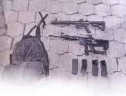 Sac à dos et armes de tir, mur avec bandes peintes, menace et violence.