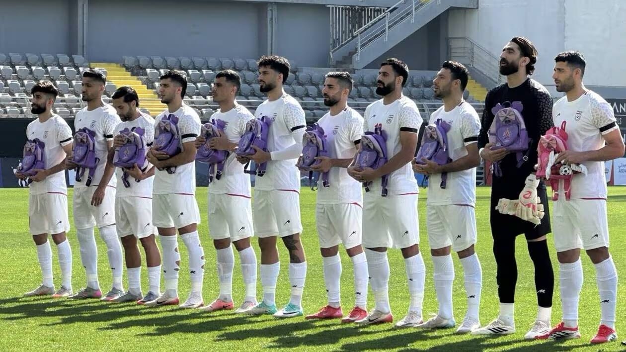 Joueurs équipe Iran portant des sacs d'écolières match Nigeria mars 2026
